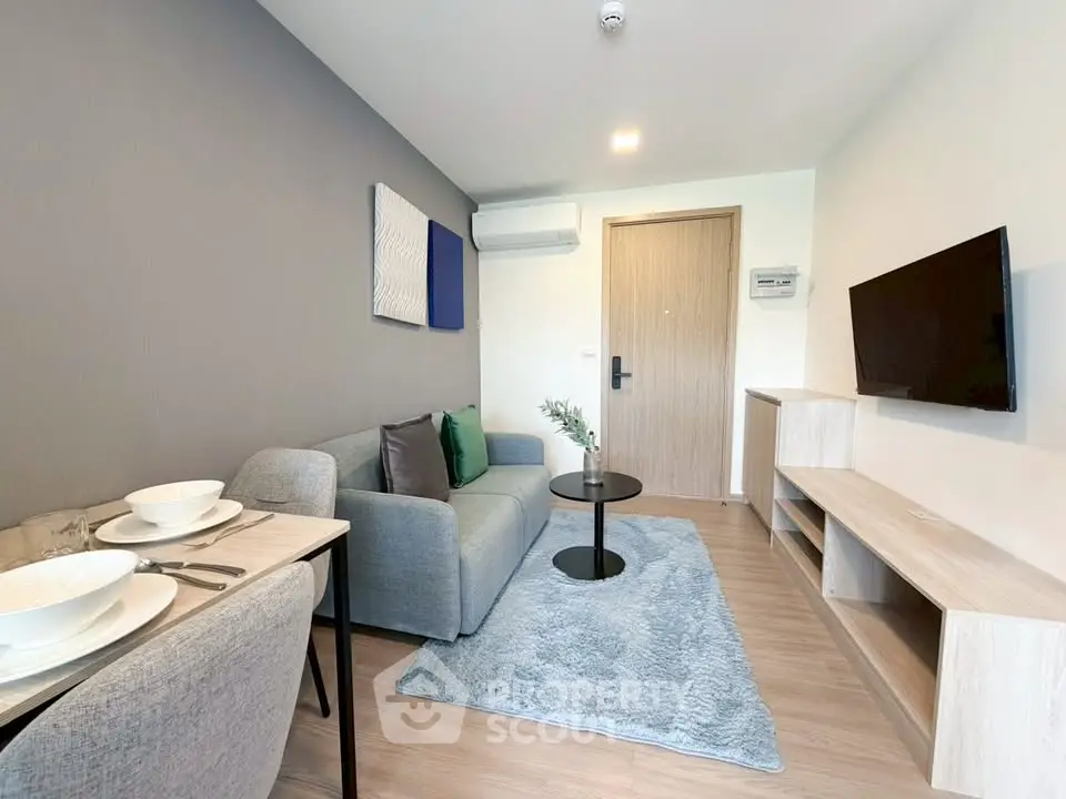 Modern living room with cozy sofa, stylish decor, and wall-mounted TV in a contemporary apartment.