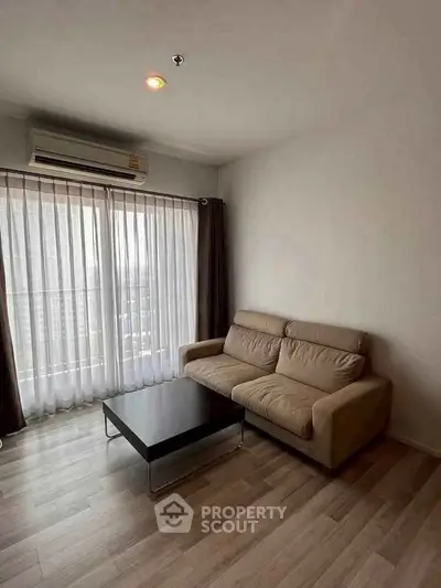 Modern living room with cozy sofa and large window offering city views.