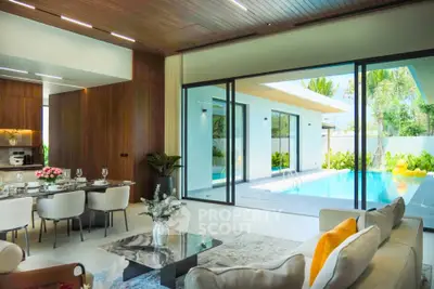 Luxurious open-plan living room with pool view, elegant dining area, and modern decor in a stunning villa.