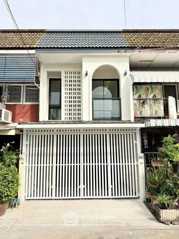 Charming townhouse with modern facade and gated entrance in a cozy neighborhood.