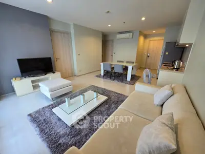 Spacious modern living room with elegant decor and open layout, featuring cozy seating and stylish dining area.