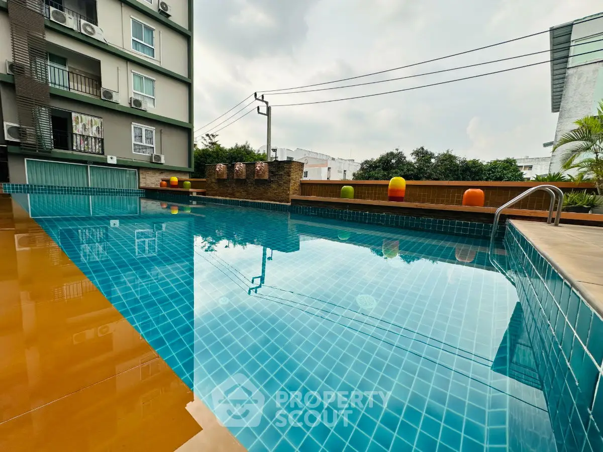 Stunning modern apartment pool with vibrant blue tiles and serene surroundings.
