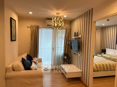 Cozy living room with modern decor and adjacent bedroom in stylish apartment.
