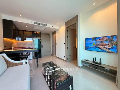Modern living room with open kitchen, sleek design, and large TV, perfect for contemporary urban living.