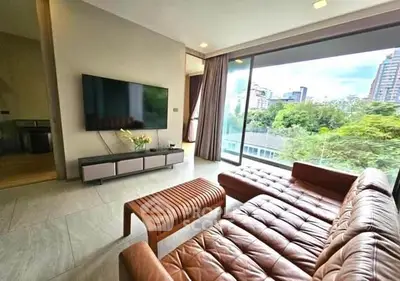 Modern living room with leather sofa and large window offering city view
