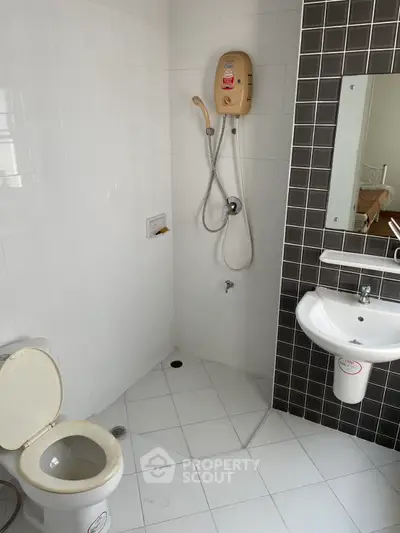 Modern bathroom with shower, toilet, and sink in a sleek design.