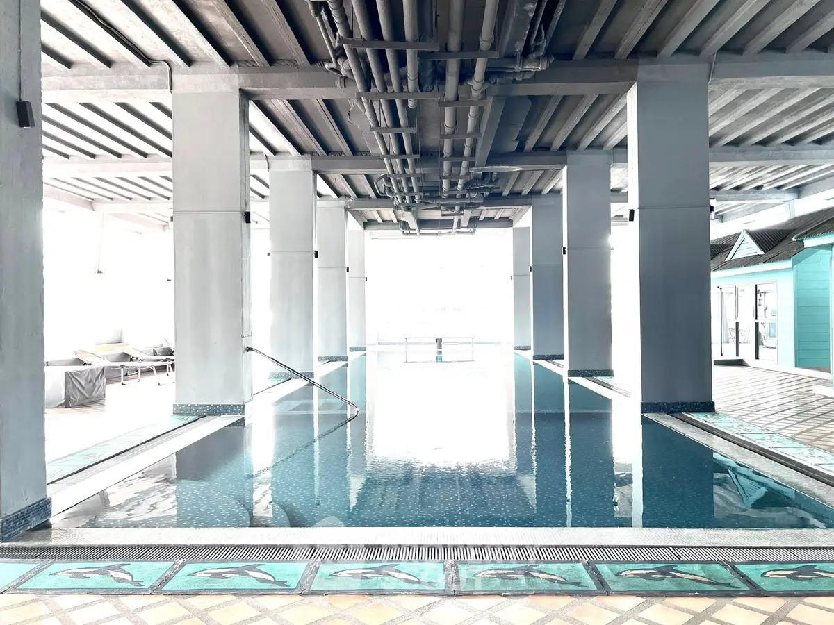 Luxurious indoor pool with modern design and ample natural light in a high-end residential building.