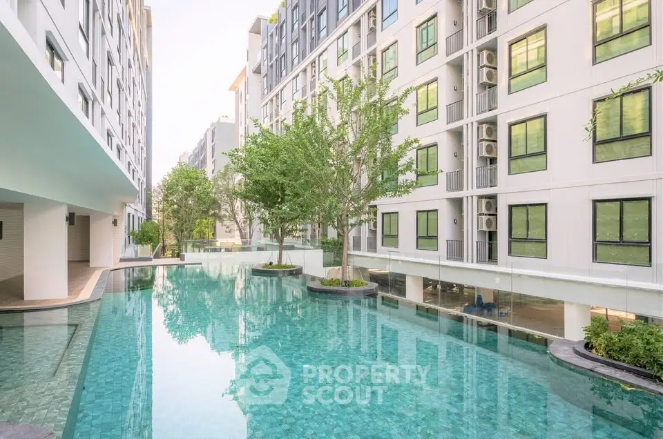 Luxurious apartment complex with a stunning outdoor pool and modern architecture.