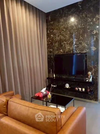 Luxurious living room with leather sofa and marble accent wall featuring a sleek TV setup.