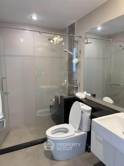 Modern bathroom with glass shower and sleek fixtures, perfect for a contemporary home.