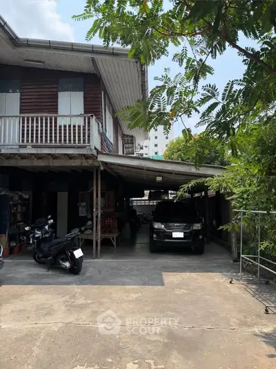 Charming traditional wooden house with spacious driveway and lush greenery, perfect for serene living.