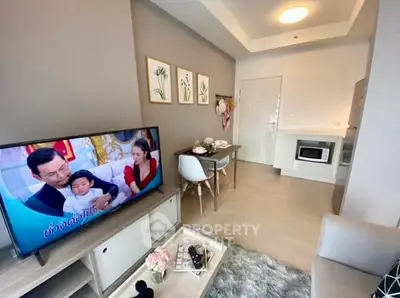 Modern living room with TV, dining area, and compact kitchen in stylish apartment.