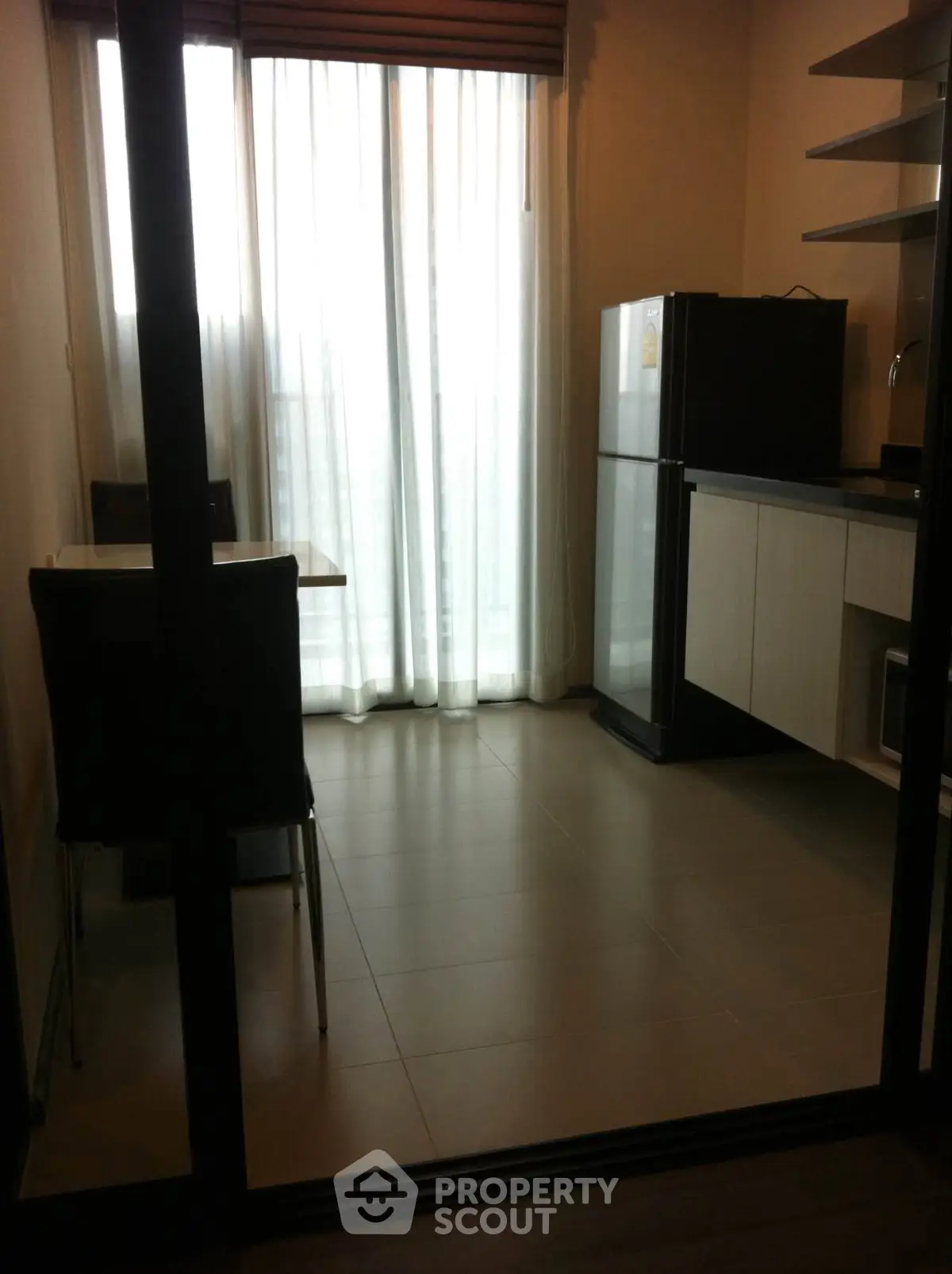 Modern kitchen with sleek appliances and dining area in a stylish apartment.