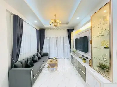 Luxurious living room with elegant decor, large sofa, and modern entertainment center.