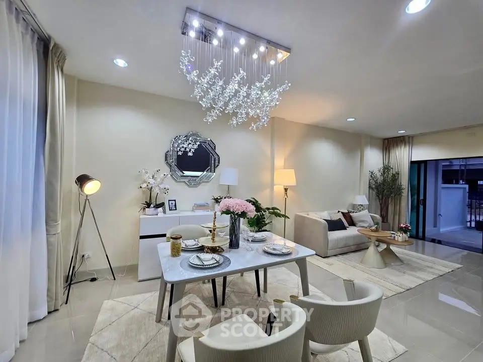 Elegant modern living room with stylish chandelier and dining area