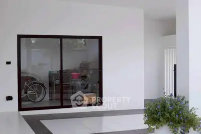 Modern home entrance with sliding glass door and tiled flooring