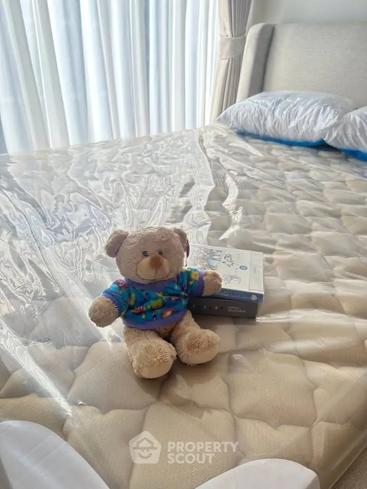Cozy bedroom with plush teddy bear on a neatly made bed, inviting and warm ambiance.
