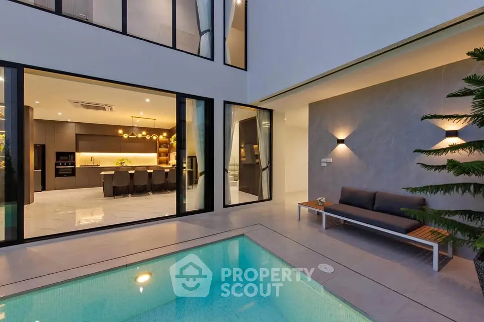 Luxurious modern home with pool and open kitchen view, perfect for entertaining.