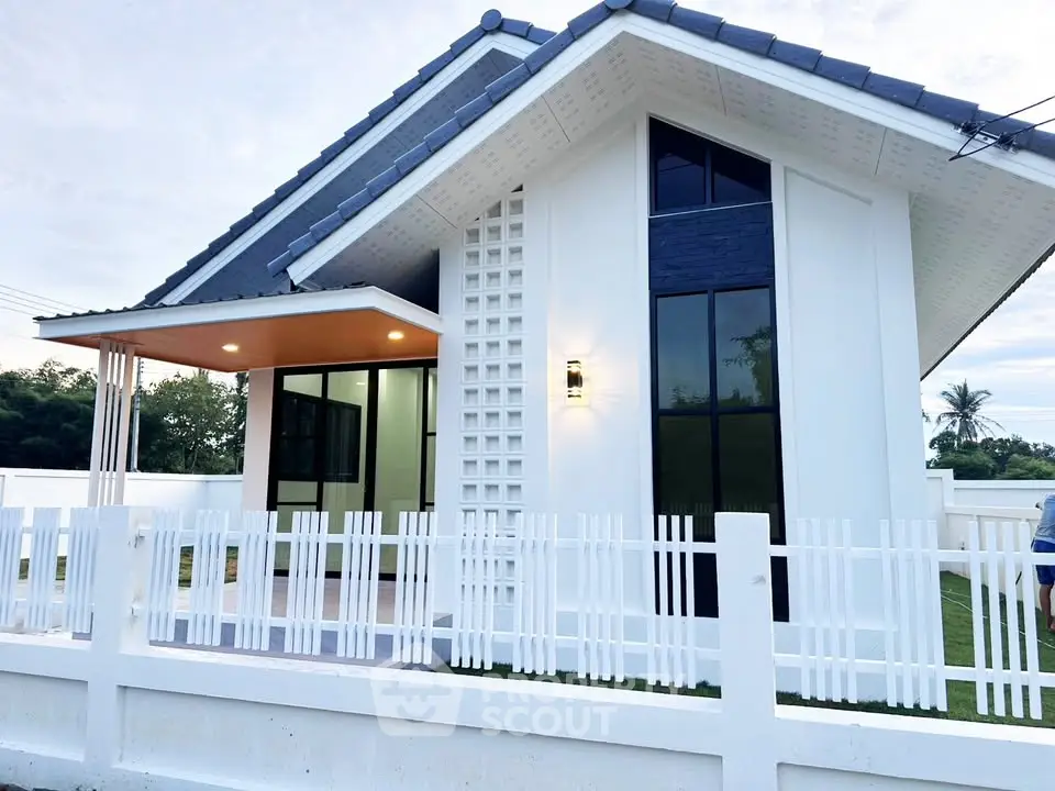 Modern single-story house with stylish architecture and white picket fence