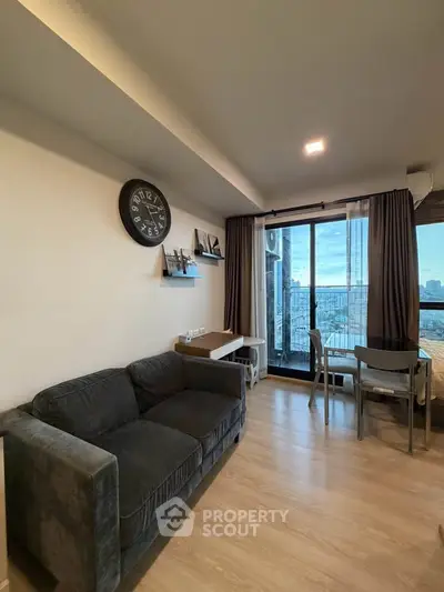 Modern living room with city view, featuring a cozy sofa and stylish decor, perfect for urban living.