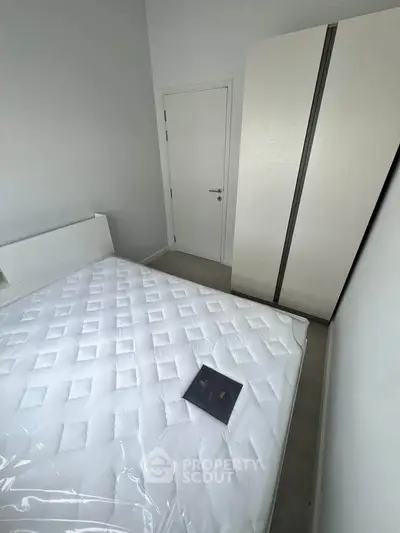 Cozy bedroom with minimalist design featuring a comfortable bed and sleek wardrobe.