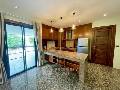 Luxurious kitchen with marble flooring and open layout, featuring modern appliances and spacious balcony access.