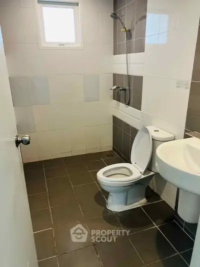 Modern bathroom with sleek tiles and contemporary fixtures in a real estate property.