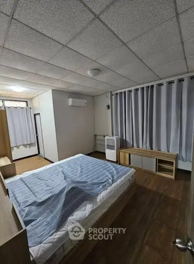 Spacious bedroom with modern furnishings and ample natural light, perfect for comfortable living.