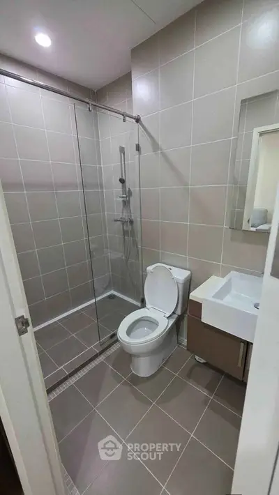 Modern bathroom with glass shower and sleek fixtures in a contemporary apartment.