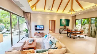 Luxurious open-plan living room with high ceilings and pool view, perfect for modern living.