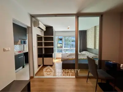 Modern apartment interior with bedroom and kitchen, featuring sleek design and natural light.