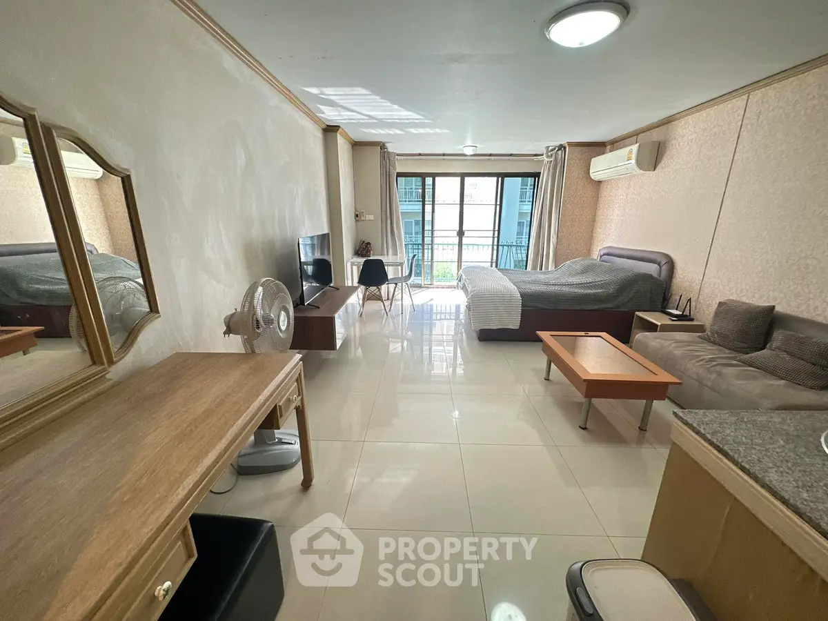 Spacious studio apartment with modern furnishings and balcony view