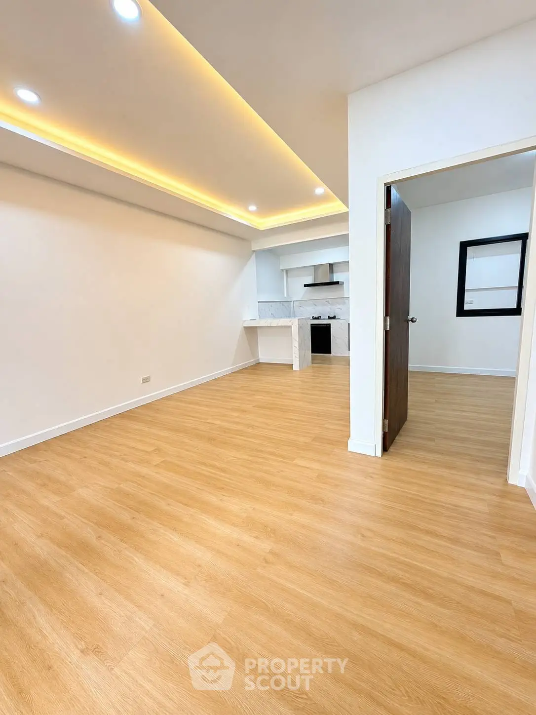 Modern open-layout living room with wooden flooring and recessed lighting