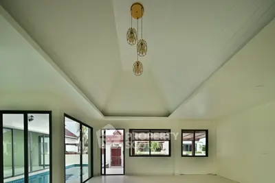 Spacious modern living room with high ceiling and pool view