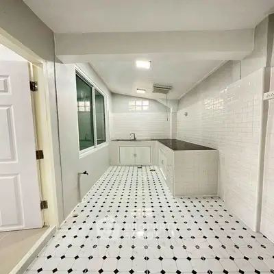 Charming kitchen with classic white tiles and modern fixtures, perfect for culinary enthusiasts.
