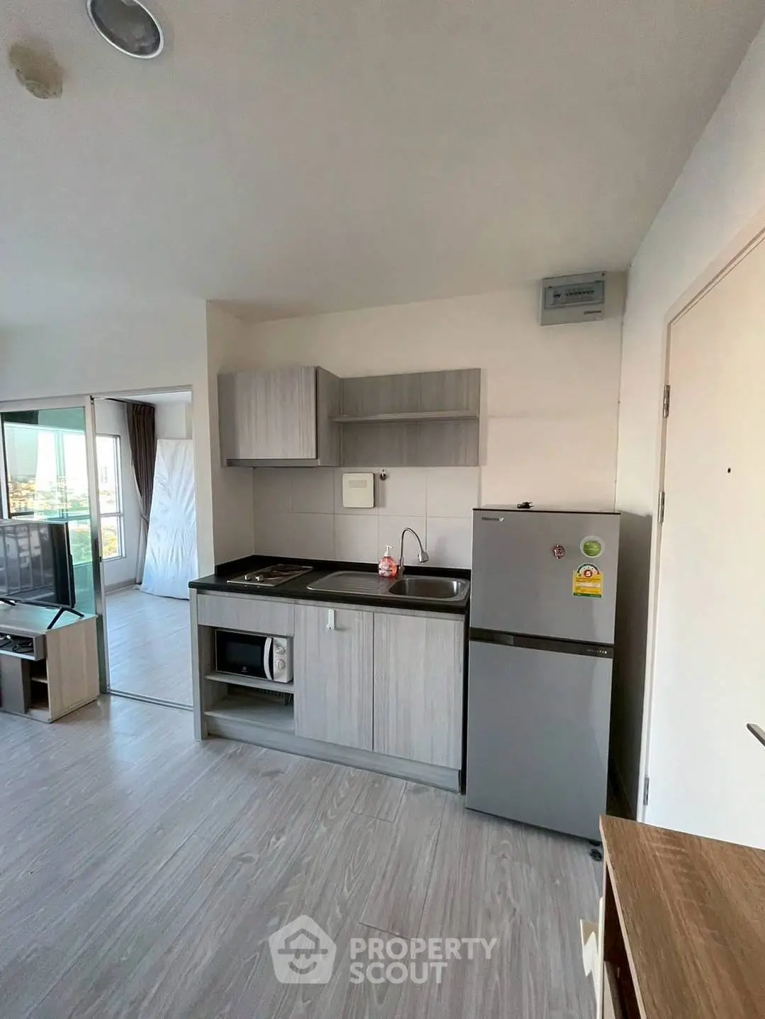 Modern kitchen with sleek cabinets and stainless steel appliances in a bright apartment.