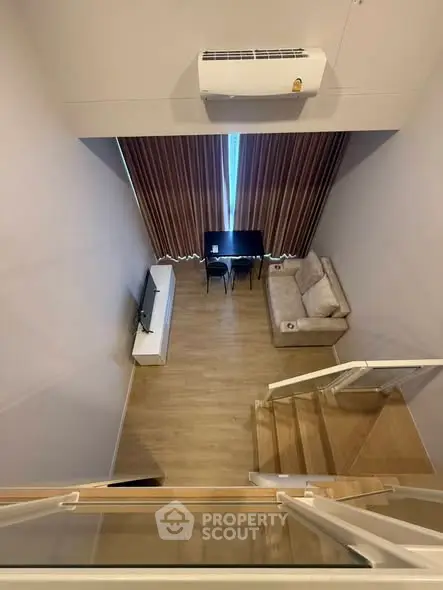 Modern loft-style living room with high ceiling and elegant decor.