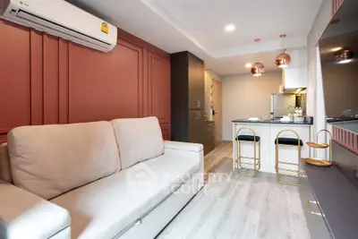 Modern living room with stylish kitchen, featuring cozy sofa and elegant lighting in open layout apartment.