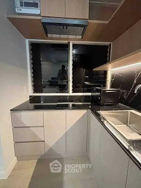 Modern kitchen with sleek cabinetry and black countertops