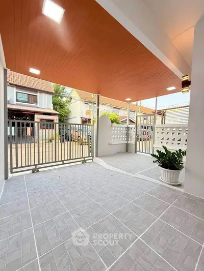 Spacious covered patio with modern tiles and stylish ceiling, perfect for outdoor relaxation.