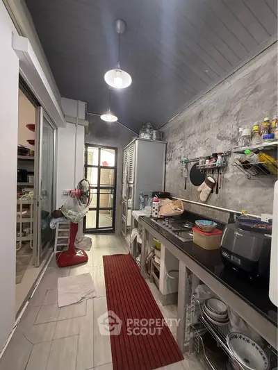 Charming kitchen with rustic concrete walls and modern appliances, featuring a cozy open layout and ample storage.