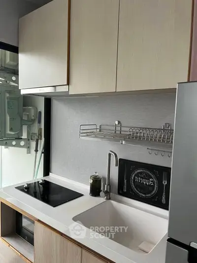 Modern kitchen with sleek cabinetry and electric stove in a compact layout.