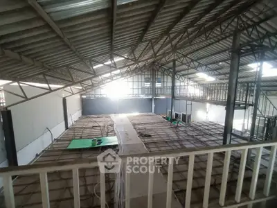 Spacious industrial warehouse with high ceilings and mezzanine level, ideal for storage or manufacturing.