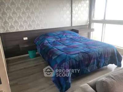 Modern bedroom with stylish wallpaper and large window offering natural light.