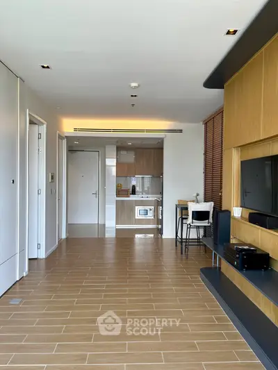 Modern open-plan living room with sleek kitchen and stylish wooden flooring, perfect for contemporary living.