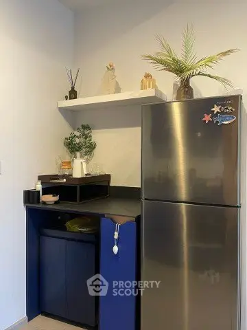 Modern kitchen corner with stainless steel fridge and stylish shelving