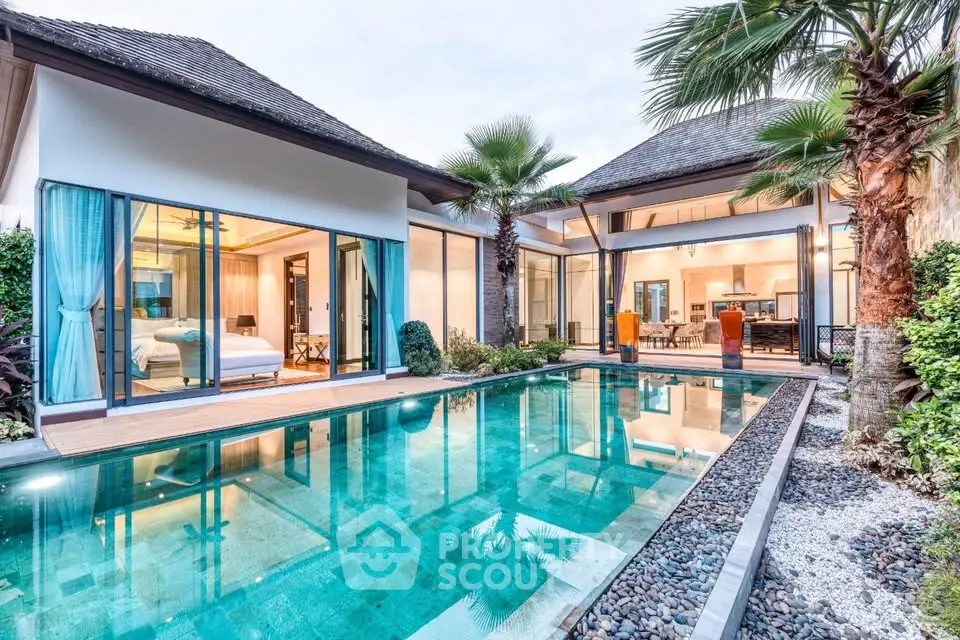 Luxurious villa with private pool and modern design, featuring spacious glass doors and tropical landscaping.