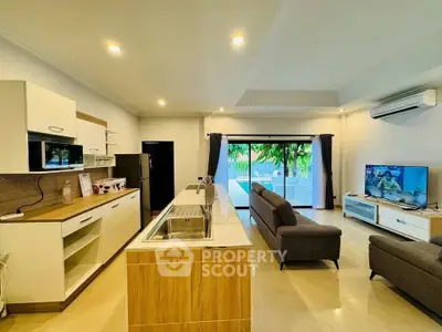 Spacious open-plan living room with modern kitchen and garden view.