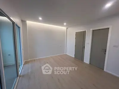 Spacious modern living room with sleek wooden flooring and recessed lighting
