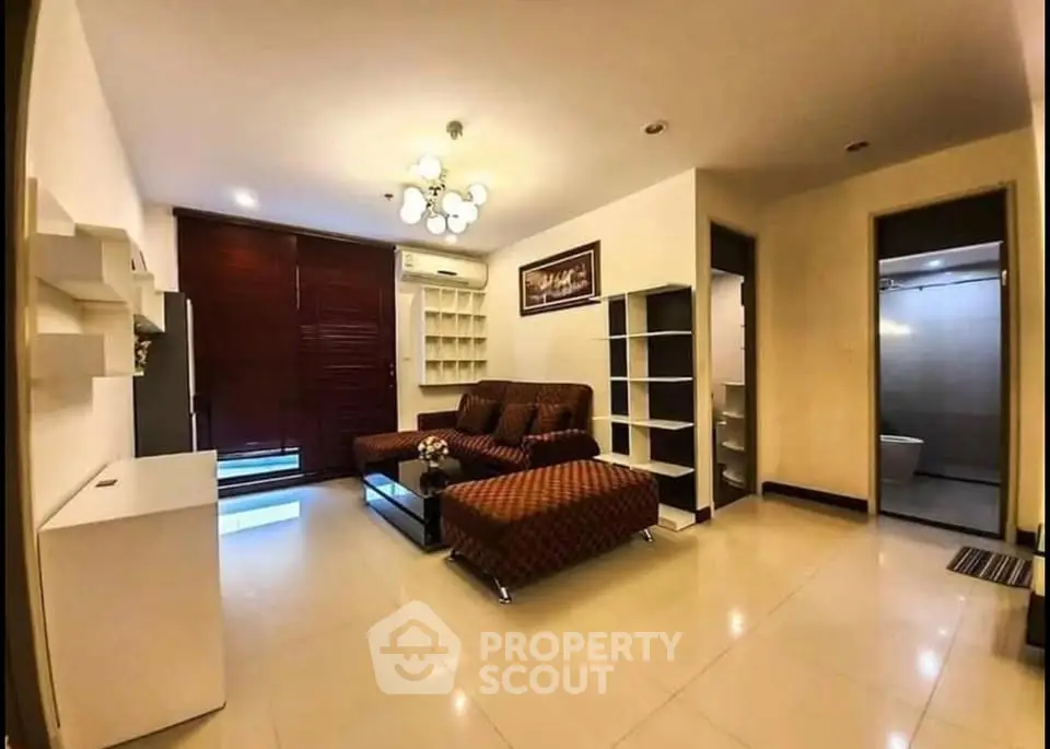 Spacious living room with modern furniture and elegant lighting in a cozy apartment.